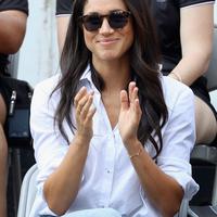 Kekasih Pangeran Harry yang juga aktris, Meghan Markle menonton pertandingan tenis kursi roda selama Invictus Games 2017 di Toronto, Kanada, Senin (25/9). Meghan tampil lebih kasual dengan kemeja putih dan jeans skinny. (Chris Jackson/GETTY IMAGES/AFP)