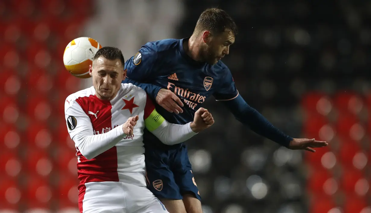 Bek Arsenal, Calum Chambers melompat saat berebut bola dengan bek Slavia Praha, Jan Boril pada leg kedua perempat final Liga Europa di Stadion Sinobo, Praha, Jumat (16/4) dini hari WIB.  Arsenal lolos ke semifinal Liga Europa setelah menang telak 4-0 di markas Slavia Praha. (AP Photo/Petr David Jose