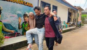 Dika Sanjaya, driver ojek online yang menjadi korban tabrak lari harus dibopong oleh istrinya ketika membuat laporan ke Polresta Bandar Lampung (Liputan6.com/Ardi Munthe)