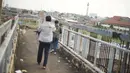 Suasana JPO yang melintang di atas jalan tol dalam kota dan Jalan Gatot Soebroto di Mampang, Jakarta, Selasa (4/2/2020). Kurangnya perawatan menyebabkan kondisi pagar JPO tersebut banyak yang berkarat sehingga berpotensi membahayakan pejalan kaki yang melintas. (Liputan6.com/Immanuel Antonius)