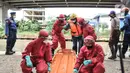 Petugas mengenakan APD saat mengevakuasi korban banjir yang terpapar Covid-19 dalam simulasi penanganan banjir di Kalimalang, Cipinang Melayu, Rabu (17/11/2021). Simulasi digelar dalam rangka kesiapsiagaan petugas dalam penanganan korban banjir.  (merdeka.com/Iqbal S Nugroho)