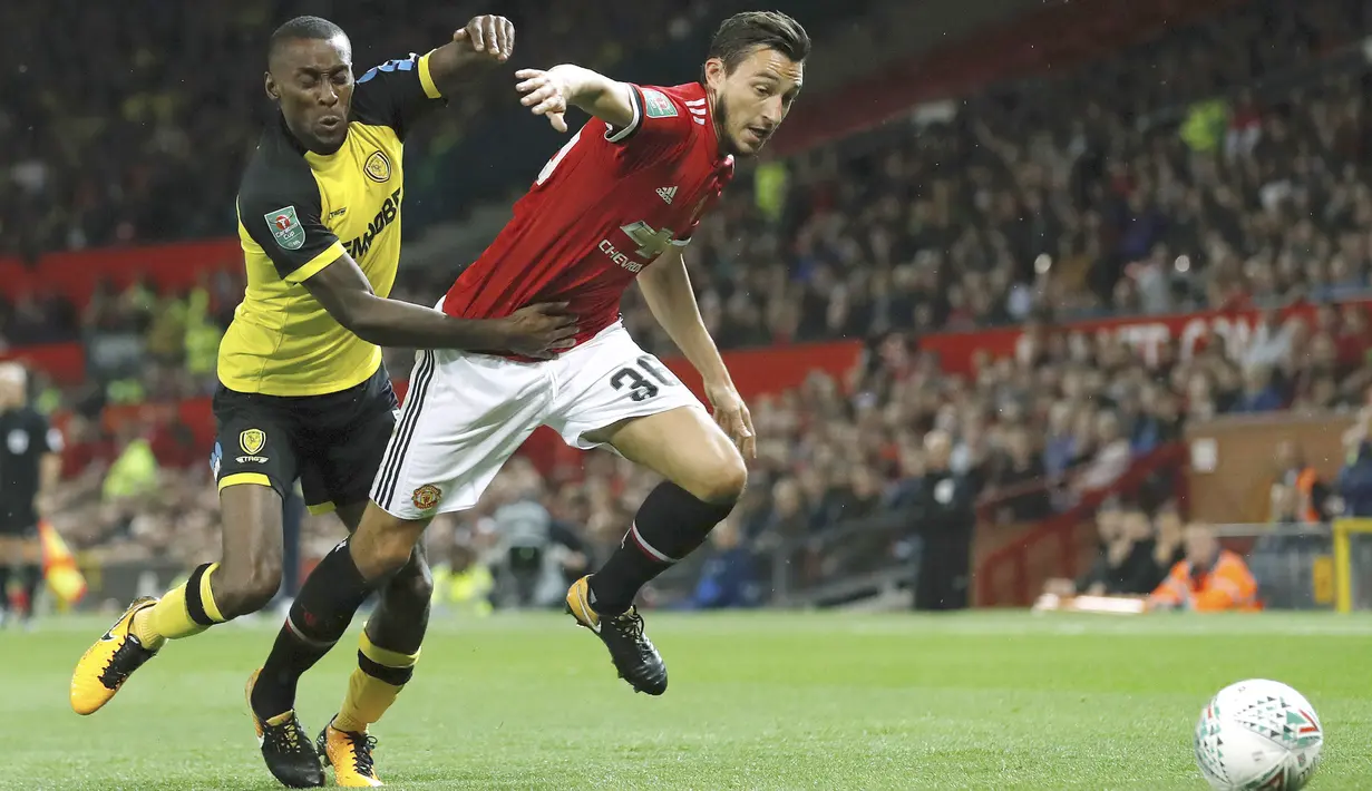 Pemain Manchester United, Matteo Darmian (kanan) berusaha melewati adangan pemain Burton Albion pada laga Piala Liga Inggris di Old Trafford, Manchester (20/9/2017). MU menang 4-1. (Martin Rickett/PA via AP)