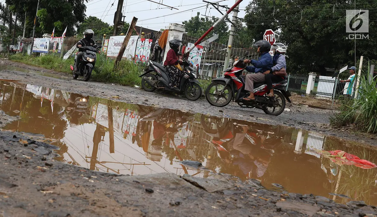 Kendaraan menghindari kubangan pada jalan yang rusak di Jalan Pertamina, Kemiri Muka, Depok, Jawa Barat, Selasa (5/3). Kondisi tersebut mengganggu aktivitas warga serta pengguna jalan. (Liputan6.com/Immanuel Antonius)