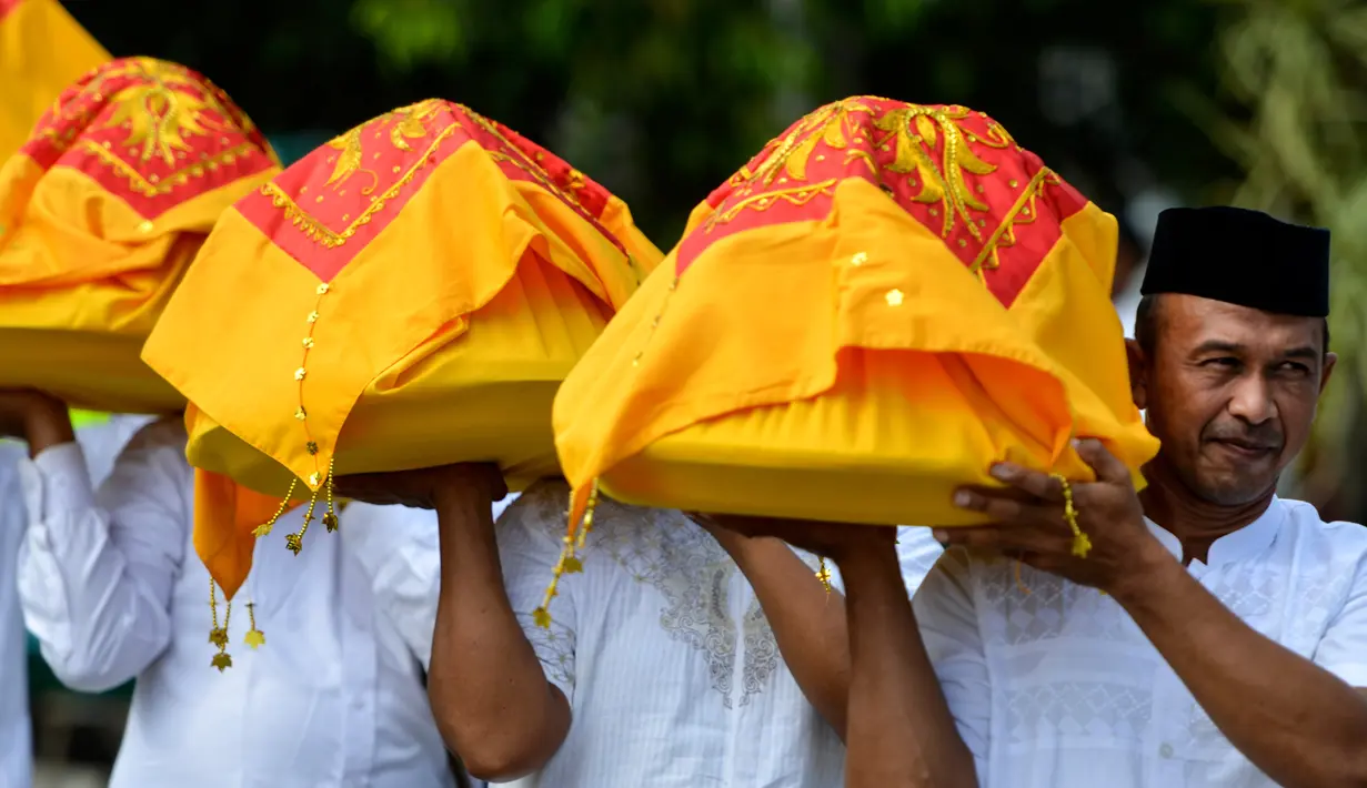 Warga membawa nampan berisi kotak makanan tradisional pada perayaan maulid akbar Nabi Muhammad SAW di Banda Aceh, Aceh, Kamis (6/2/2020). Acara itu menyediakan 808 hidangan dari 90 desa dan instansi pemerintah dengan mengundang 25.000 tamu dari berbagai daerah. (Photo by Chaideer MAHYUDDIN / AFP)