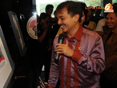 Roy Suryo melihat foto-foto yang mendokumentasikan kegiatannya selama setahun menjabat sebagai Menpora (Liputan6.com/Helmi Fithriansyah).