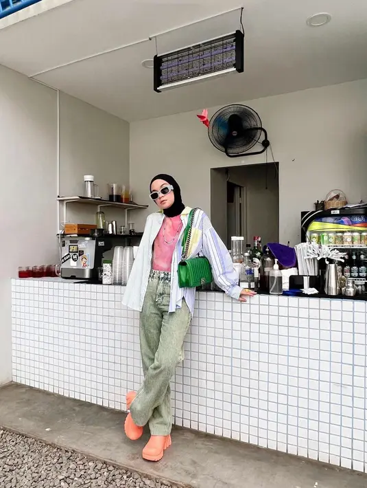 <p>Strip kemeja warna biruyang dijadikan outer dipadu padankan dengan inner berwarna pink dan celana jeans. (instagram/tantrinamirah)</p>