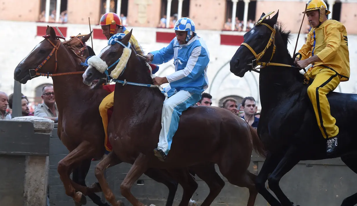 Para joki memacu kudanya saling balap saat mengikuti balapan kuda Italia historis Palio di Siena, Italia (16/8). Palio diadakan dua kali setahun, yakni Juli dan Agustus. (AFP Photo/Filippo Monteforte)