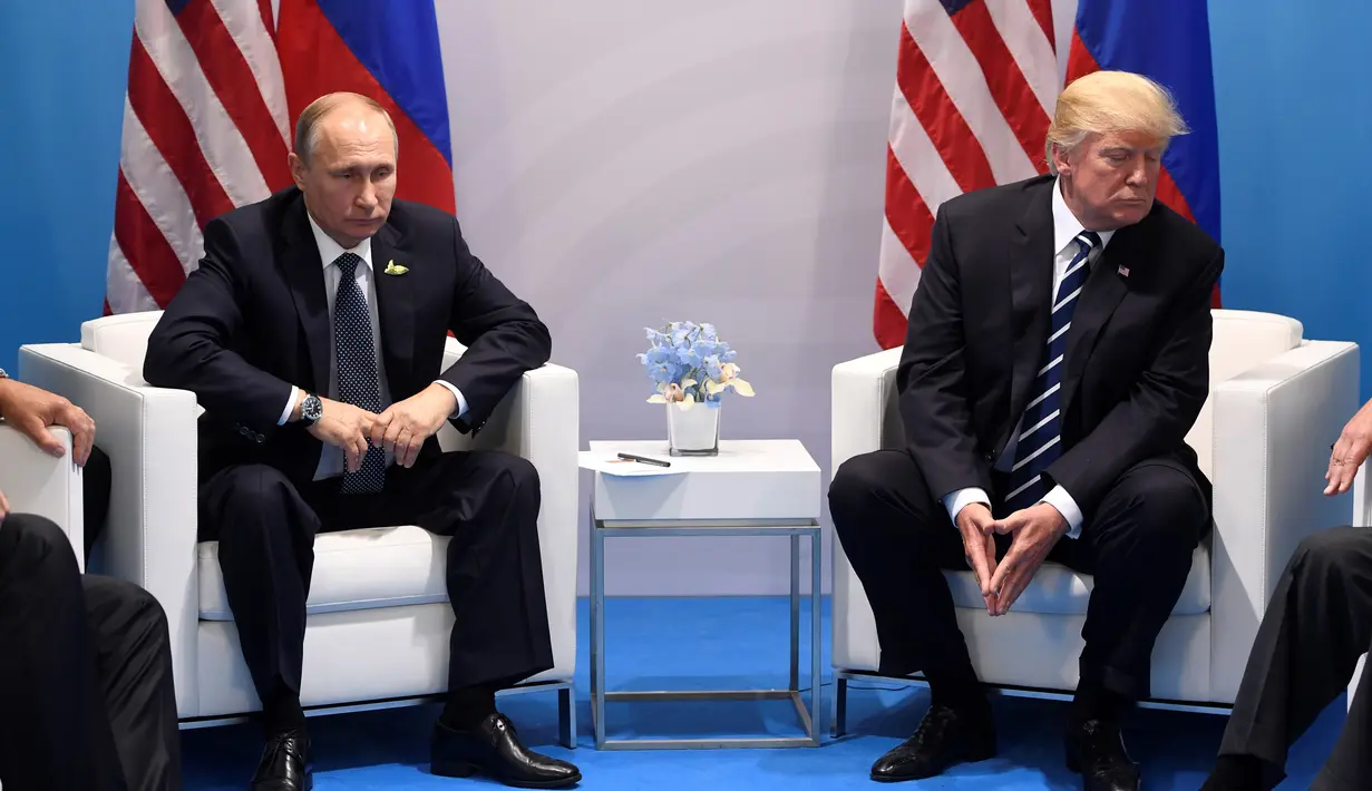 Ekspresi Presiden AS, Donald Trump dan Presiden Rusia Vladimir Putin saat bertemu di KTT G20, di Hamburg, Jerman (7/7). Pertemuan kedua pemimpin negara adidaya ini menjadi sorotan dunia. (AFP Photo/Soul Loeb)