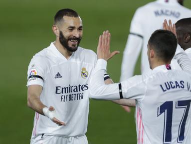 Striker Real Madrid, Karim Benzema (kiri) merayakan gol pertama Real Madrid yang dicetaknya ke gawang Barcelona dalam laga lanjutan Liga Spanyol 2020/2021 pekan ke-30 di Alfredo di Stefano Stadium, Madrid, Sabtu (10/4/2021). Real Madrid menang 2-1 atas Barcelona. (AP/Manu Fernandez)