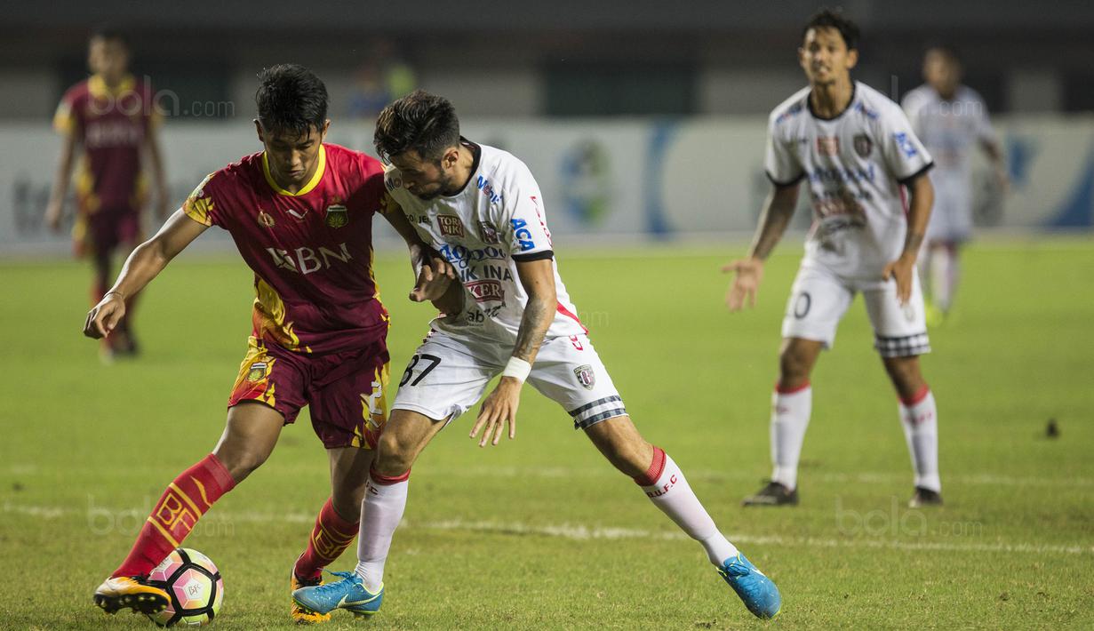 Bek Bhayangkara FC, Putu Gede, mengamankan bola dari gelandang Bali United, Stefano Lilipaly, pada laga Liga 1 Indonesia di Stadion Patriot, Bekasi, Jumat (29/9/2017). Bhayangkara menang 3-2 atas Bali. (Bola.com/Vitalis Yogi Trisna)