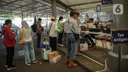 Sejumlah calon penumpang antre untuk menjalani tes swab PCR di Stasiun Pasar Senen, Jakarta, Jumat (24/12/2021). Layanan ini untuk membantu masyarakat dalam melengkapi persyaratan naik kereta pada masa Natal dan Tahun Baru. (Liputan6.com/Faizal Fanani)