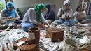 Sejumlah ibu membuat kerajinan tangan dari koran bekas di Kampung Sirnasari, Tanah Baru, Bogor, Rabu (13/2). Kegiatan industri rumahan tersebut melibatkan lebih dari 30 ibu di lingkungan RT yang sudah berjalan selama 6 tahun. (Merdeka.com/Arie Basuki)