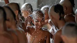 Ekspresi seorang bocah saat mengikuti mandi suci untuk menandai festival Janai Purnima di kuil Pashupati di Kathmandu, Nepal (28/7). (AP Photo / Niranjan Shrestha)