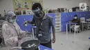 Terapis atau pengajar membimbing mahasiswa berkebutuhan merebus telur asin saat kelas terapi mata kuliah wirausaha di Lembaga Pendidikan dan Keterampilan Kampusnya Manusia, Kranggan, Bekasi, Jawa Barat, Kamis (3/12/2020). (merdeka.com/Iqbal S. Nugroho)