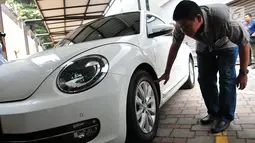 Calon peserta lelang mengecek kondisi mobil hasil sitaan kasus korupsi di Gedung KPK, Jakarta, Selasa (19/9). KPK melelang sebanyak 19 unit mobil dari berbagai model dan merek dengan harga termurah Rp28,8 jutaan. (Liputan6.com/Helmi Afandi)