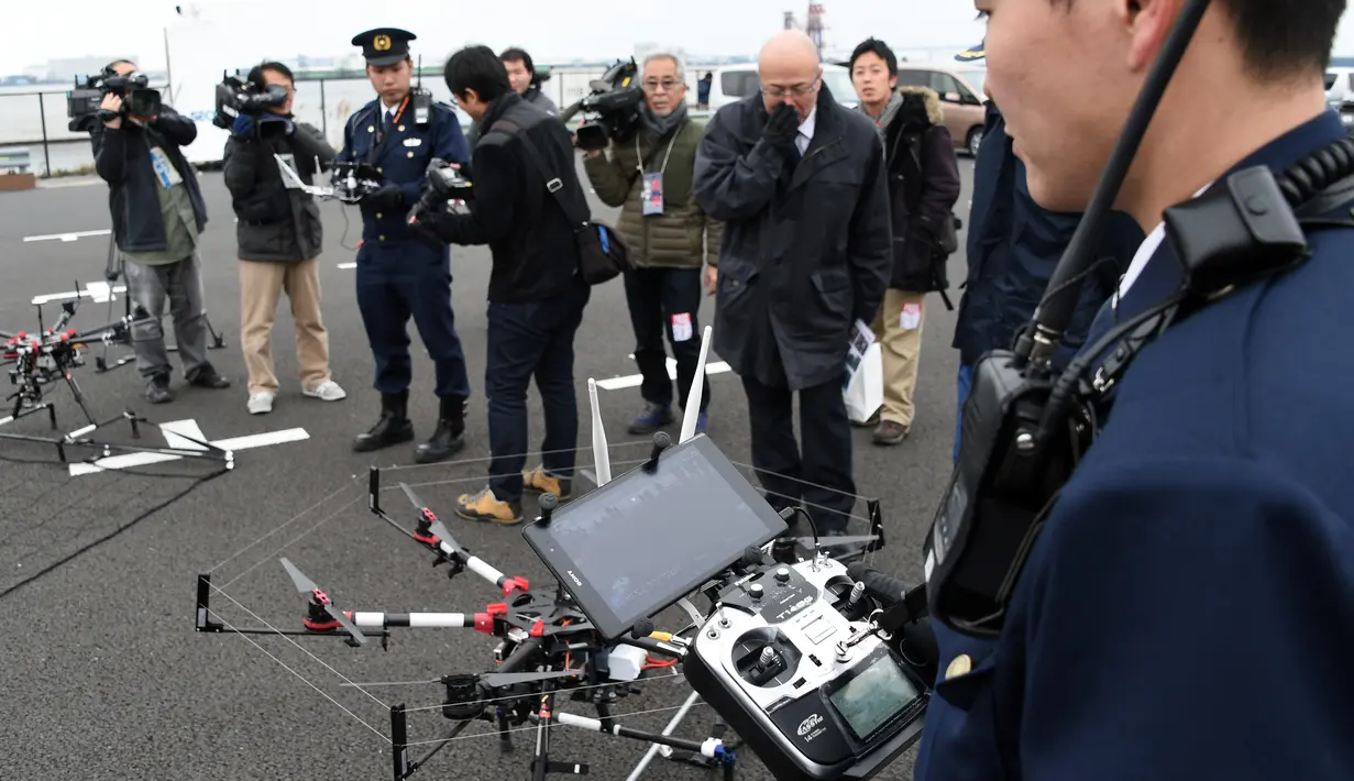 Petugas kepolisian menyiapkan drone yang dilengkapi jaring saat latihan penanggulangan anti terorisme di Tokyo, Jepang, Minggu (17/1). Latihan yang diikuti 400 petugas kepolisian dan keamanan ini untuk persiapan acara Tokyo maraton (AFP/Toshifum Kitamura)