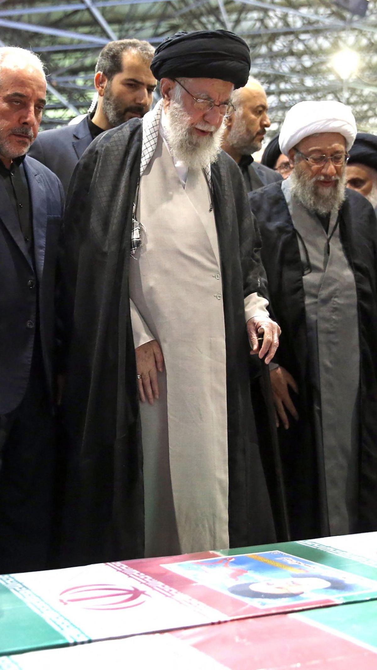 Diapit oleh para pejabat tinggi, Ayatollah Khamenei memimpin salat di depan peti jenazah Ebrahim Raisi dan tujuh pendampingnya yang meninggal dunia dalam kecelakaan helikopter.&nbsp;Foto: Iranian Supreme Leader's Website/AFP