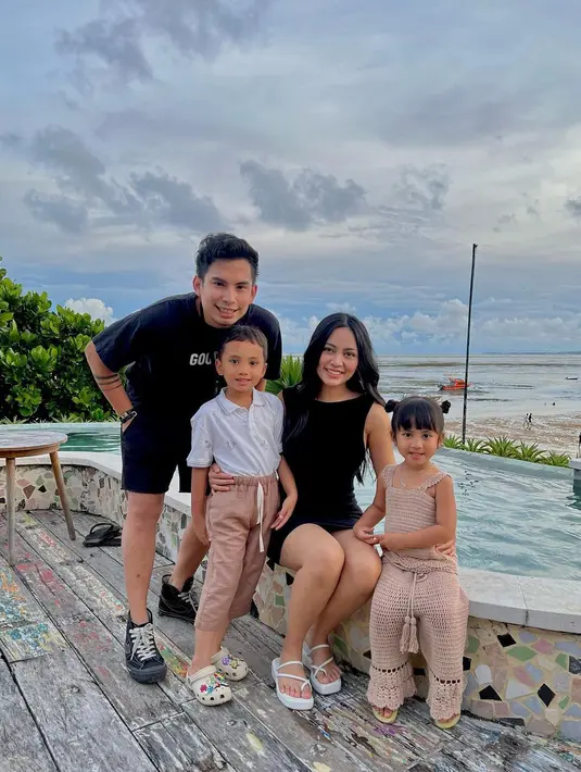 Keluarga kecil Rachel Vennya dan Okin dalam foto ini tampil dengan outfit kompak. Rachel mengenakan mini dress hitam tanpa lengan, sedangkan Okin kembali dengan kaus dan celana pendek yang semuanya berwarna hitam. Sedang kedua anaknya tampil gemas, abang dengan kemeja putih dan celana panjang cokelat, sedangkan adik tampil dengan set rajut atasan tanpa lengan dan celana panjangnya. Foto: Instagram.