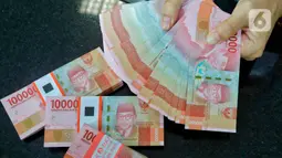 Pegawai memperlihatkan mata uang rupiah di salah satu gerai penukaran mata uang di Jakarta, Kamis (5/1/2023). Nilai tukar rupiah ditutup di level Rp15.616 per dolar AS pada Kamis (5/1) sore ini. Mata uang Garuda melemah 34 poin atau minus 0,22 persen dari perdagangan sebelumnya. (Liputan6.com/Angga Yuniar)