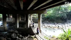 Pengendara motor melewati jembatan Ciliwung yang berada di bawah tol ruas Gadog, Ciawi, Bogor (16/68). Jembatan ini menjadi jalan alternatif bagi pemotor dari kawasan Bogor menuju arah Puncak dan Sukabumi. (Merdeka.com/Arie Basuki)