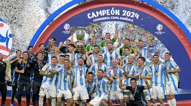 Penyerang Argentina, Lionel Messi (tengah) mengangkat trofi saat merayakan kemenangan usai final turnamen Copa America 2024 melawan Kolombia di Stadion Hard Rock, Miami, Florida pada 14 Juli 2024 atau Senin 15 Juli 2024 WIB. (JUAN MABROMATA/AFP)