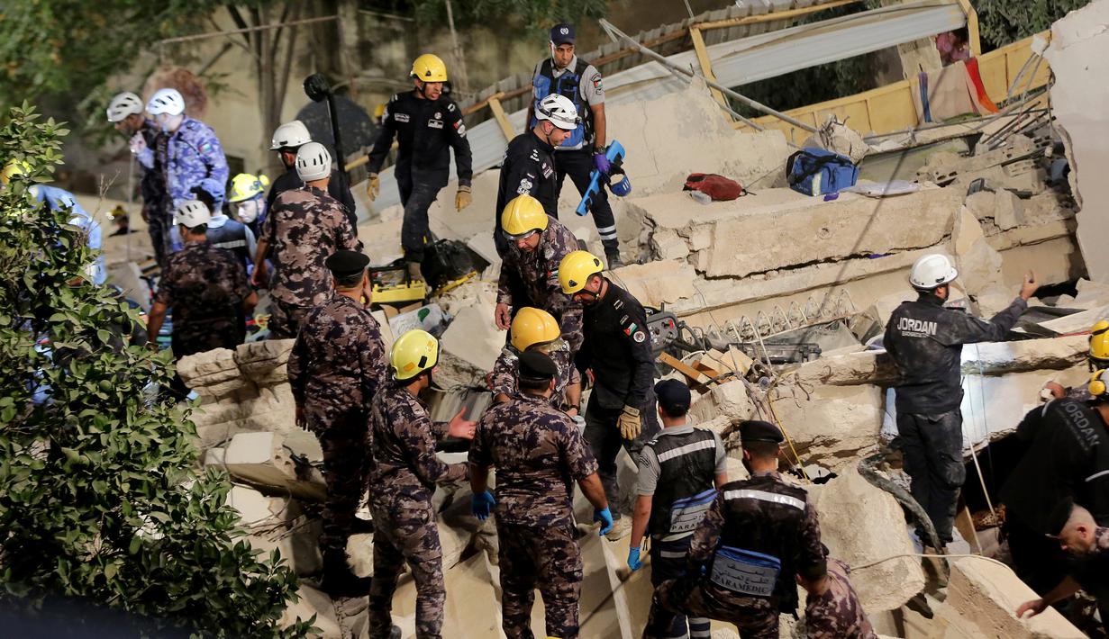 Tim penyelamat Pertahanan Sipil Yordania melakukan operasi pencarian terhadap penghuni sebuah bangunan perumahan berlantai empat yang runtuh, menewaskan sedikitnya lima orang dan tujuh orang luka-luka, di Amman, Yordania, Selasa (13/9/2022). Pihak berwenang belum memberikan keterangan jelas apa penyebab runtuhnya bangunan tersebut, menurut media pemerintah dikarenakan struktur bangunan yang sudah tua. (AP Photo/Raad Adayleh)