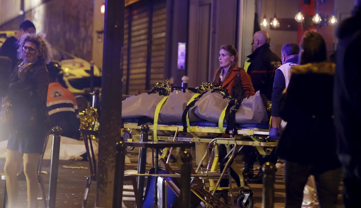 Petugas mengevakuasi korban yang tewas dari penembakan dan bom bunuh diri yang dilakukan teroris di Paris, Perancis, Jumat (13/11/2015). Dikabarkan ada 140 orang tewas dalam aksi teroris tersebut. (Reuters)