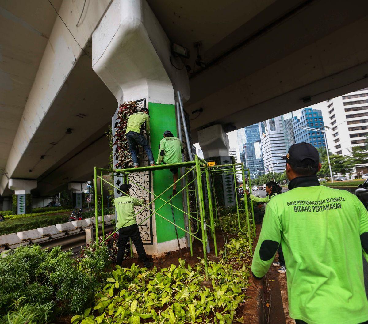 Pekerja dari Dinas Pertamanan dan Hutan Kota DKI Jakarta melakukan perbaikan pada rangka taman vertikal di Kawasan Jalan Jenderal Sudirman, Jakarta, Senin (11/3/2024). Foto: Liputan6.com / Angga Yuniar<br>