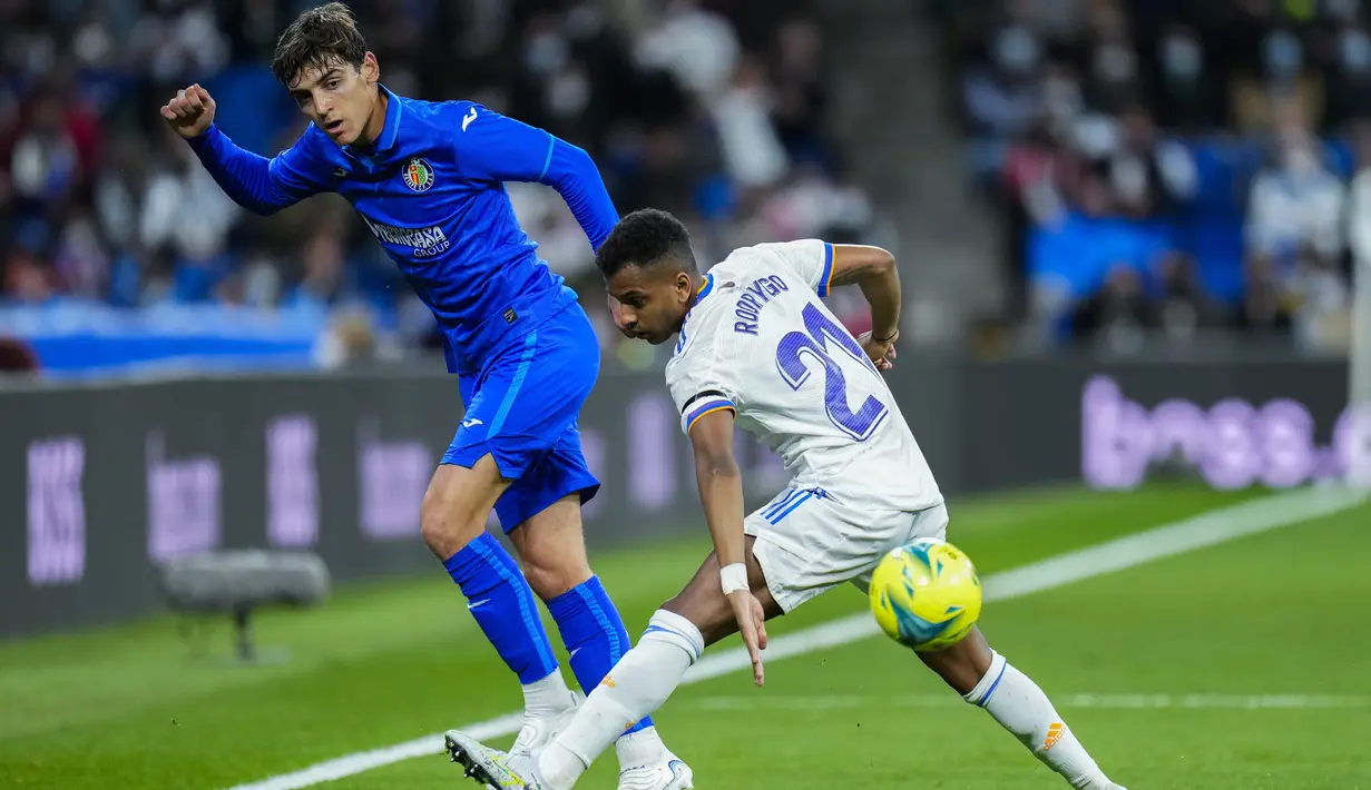 Gelandang Getafe, Gonzalo Villar berusaha melewati pemain Real Madrid, Rodrygo pada pertandingan lanjutan La Liga Spanyol di stadion Santiago Bernabeu di Madrid, Minggu (10/4/2022). Real Madrid menang atas Getafe 2-0. (AP Photo/Manu Fernandez)