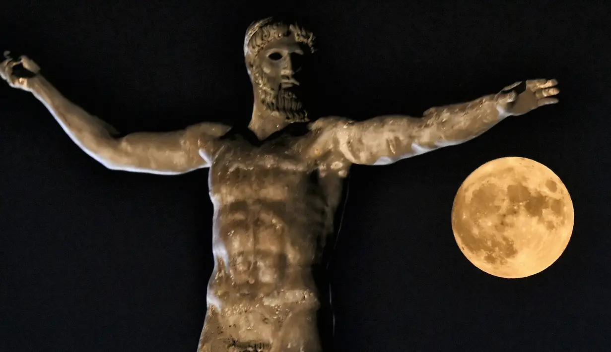 Super Moon terbit di atas patung dewa Yunani kuno Poseidon di Korintus Kuno dekat Athena pada Kamis (11/8/2022). Bulan Purnama Agustus 2022 akan menjadi fenomena Supermoon terakhir tahun ini. Bulan Purnama Agustus dijuluki "Sturgeon Moon". (Valerie GACHE / AFP)