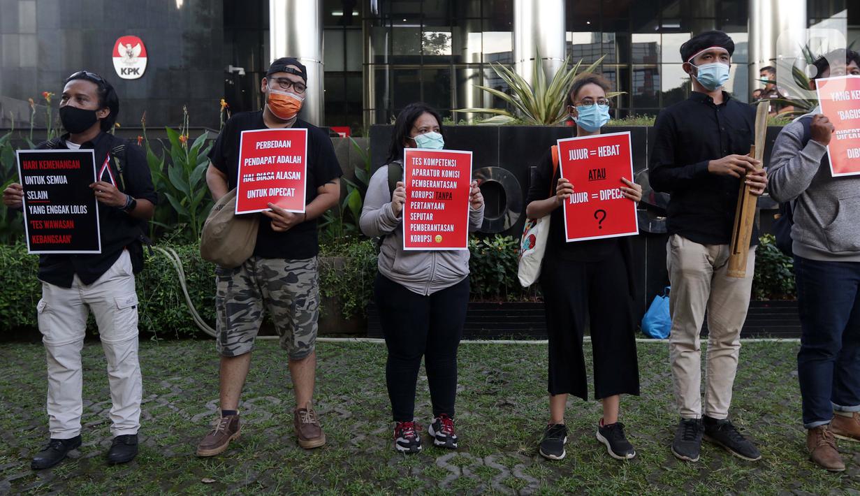 Peserta aksi dari Koalisi Masyarakat Sipil AntiKorupsi membawa poster saat berunjukrasa di depan Gedung KPK Jakarta, Selasa (18/5/2021). Dalam aksinya, sambil membunyikan kentongan mereka memberi dukungan kepada 75 pegawai KPK yang dinyatakan tidak lulus TWK. (Liputan6.com/Helmi Fithriansyah)