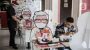 Pelayan merapikan banner bergambar karakter di KFC Salemba, Jakarta, Selasa (23/6/2020). Banner bergambar tersebut berguna untuk pembatas bagi pengunjung yang makan di tempat saat fase kenormalan baru. (Liputan6.com/Faizal Fanani)