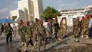 Sejumlah tentara mengamankan lokasi ledakan bom mobil yang terjadi dekat pos pemeriksaan parlemen dan Kementerian Dalam Negeri di Ibu Kota Somalia, Mogadishu, Minggu (25/3). Mobil meledak sebelum pasukan keamanan memeriksanya. (AP/Farah Abdi Warsameh)