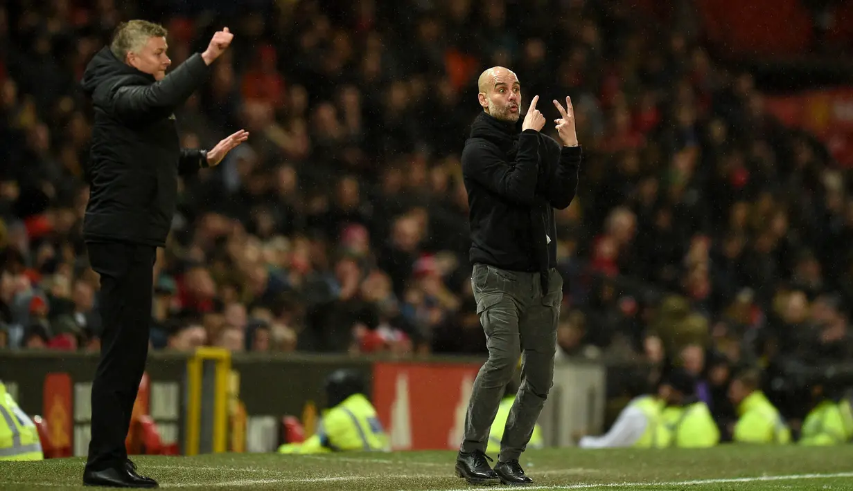 Pelatih Manchester City Pep Guardiola (kanan) dan Manajer Manchester United Ole Gunnar Solskjaer memberi isyarat kepada para pemain mereka saat pertandingan Liga Inggris di Old Trafford, Manchester, Inggris, Minggu (8/3/2020). Manchester United menang 2-0. (Oli SCARFF/AFP)