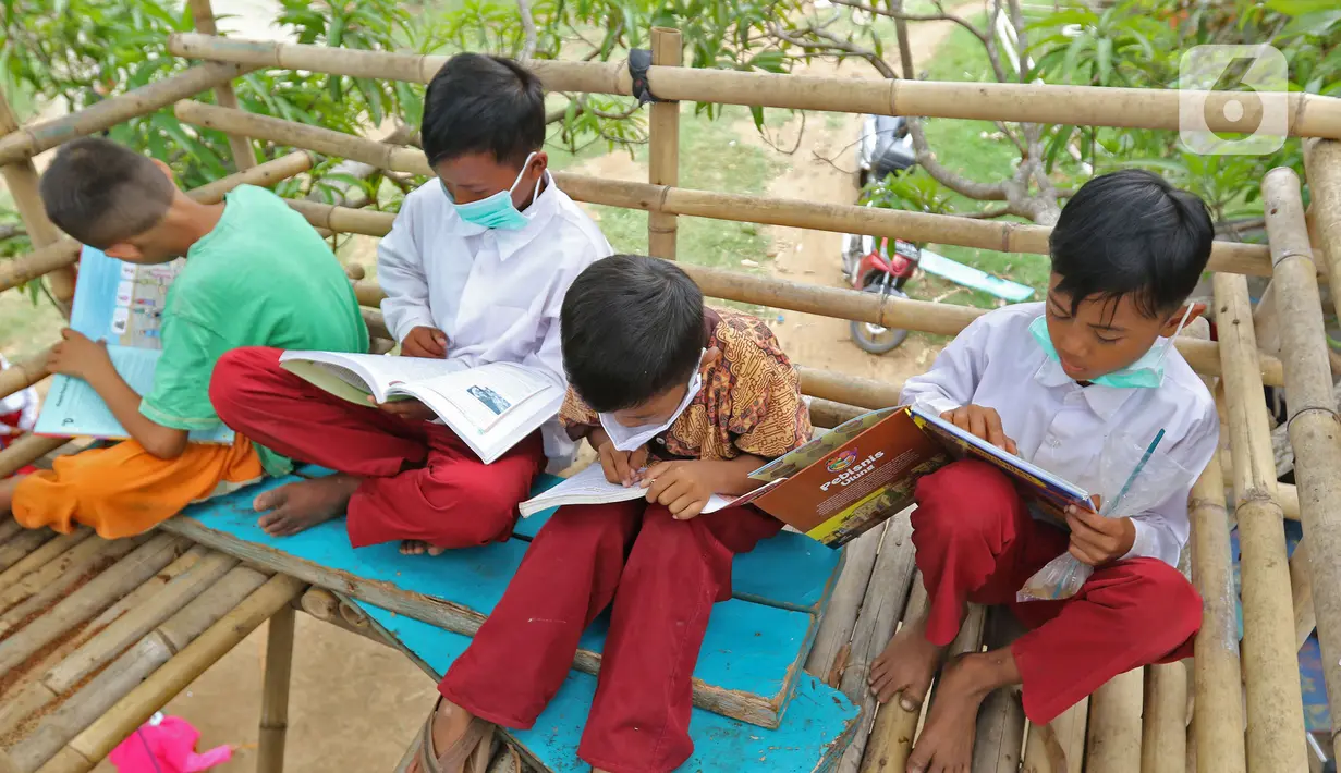 Sejumlah murid SD sedang membaca buku di sekolah alam Sukawangi, Kabuapaten Bekasi, Jawa Barat, Senin (30/11/2020). Kegiatan bermain di alam terbuka menjadi solusi bagi para murid untuk menghilangkan rasa jenuh usai belajar dimasa pandemi COVID-19. (Liputan6.com/Herman Zakharia)