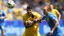 Striker Timnas Rumania, Florinel Coman (kiri) berebut bola dengan bek Timnas Ukraina, Yukhym Konoplia pada laga Grup E Euro 2024 di Allianz Arena, Munchen, Jerman, Senin (17/6/2024). (AP Photo/Matthias Schrader)