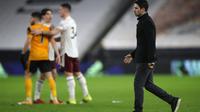 Manajer Arsenal Mikel Arteta berjalan lemas usai timnya dikalahkan Wolverhampton Wanderers pada laga lanjutan Liga Inggris 2020/2021, Rabu (03/02/2021) dini hari WIB. (AFP)