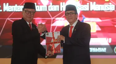 Yasonna Laoly (kanan) salam komando dengan Tjahjo Kumolo saat serah terima jabatan Menteri Hukum dan Hak Asasi Manusia (Menkumham) di Jakarta, Rabu (23/10/2019). Yasonna Laoly menggantikan Tjahjo Kumolo yang sebelumnya menjabat Plt Menkumham. (merdeka.com/Dwi Narwoko)