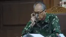 Terdakwa perkara merintangi penyidikan dugaan korupsi E-KTP, Bimanesh Sutarjo melihat berkas saat mengikuti sidang lanjutan di Pengadilan Tipikor, Jakarta, Senin (23/4). Sidang mendengar keterangan saksi. (Liputan6.com/Helmi Fithriansyah)