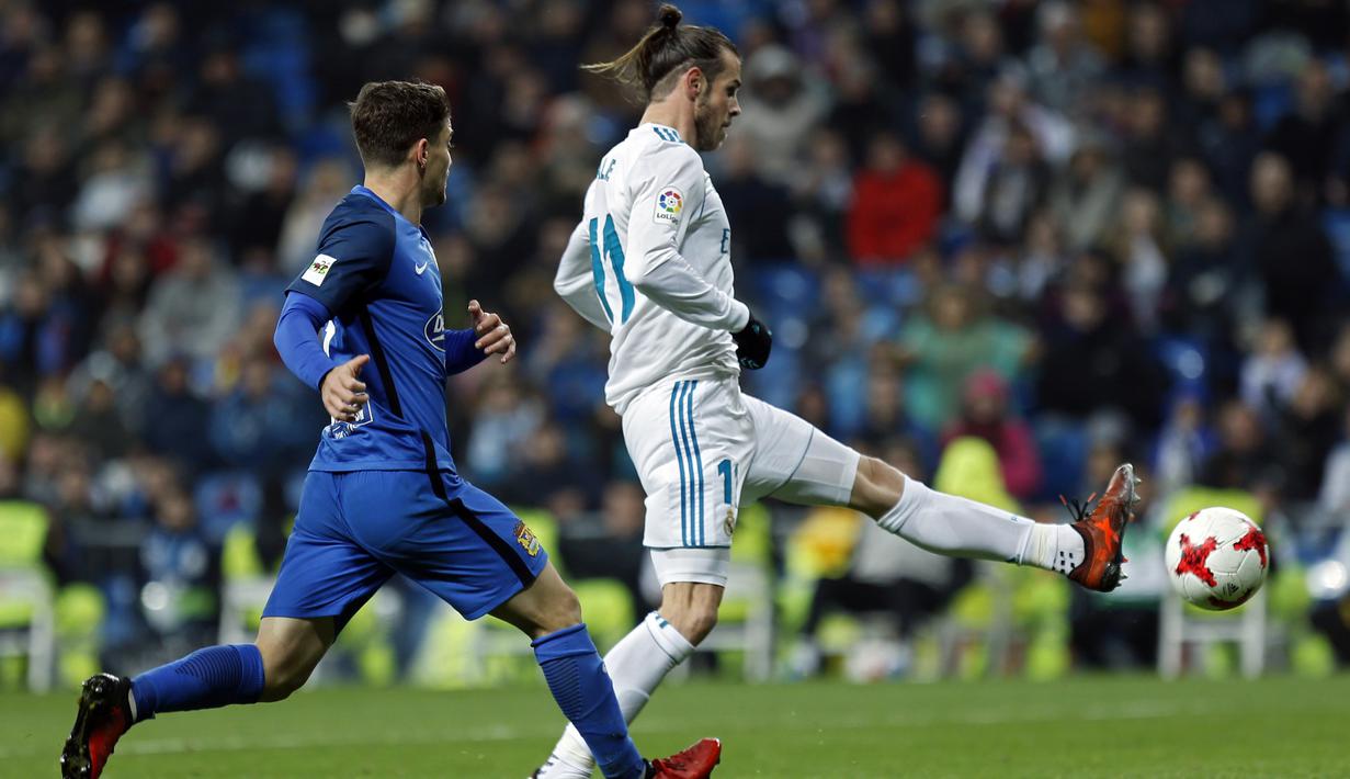 Pemain Real Madrid, Gareth Bale melepaskan umpan saat dibayangi pemain Fuenlabrada, Fran Garcia (kiri) pada laga Copa del Rey babak 32  besar di Santiago Bernabeu stadium, Madrid, (28/11/2017). Real Madrid bermain imbang 2-2. (AP/Francisco Seco)