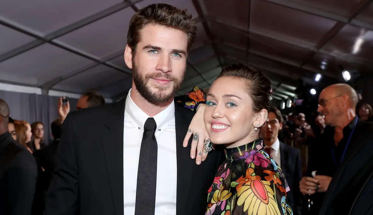 Kemesraan Miley Cyrus dan Liam Hemsworth di karpet merah premier film 'Thor: Ragnarok' di California, 10 Oktober 2017. Miley terlihat begitu manja saat meletakkan kepalanya di pundak pemain film THE HUNGER GAMES itu. (Rich Polk/Getty Images/AFP)