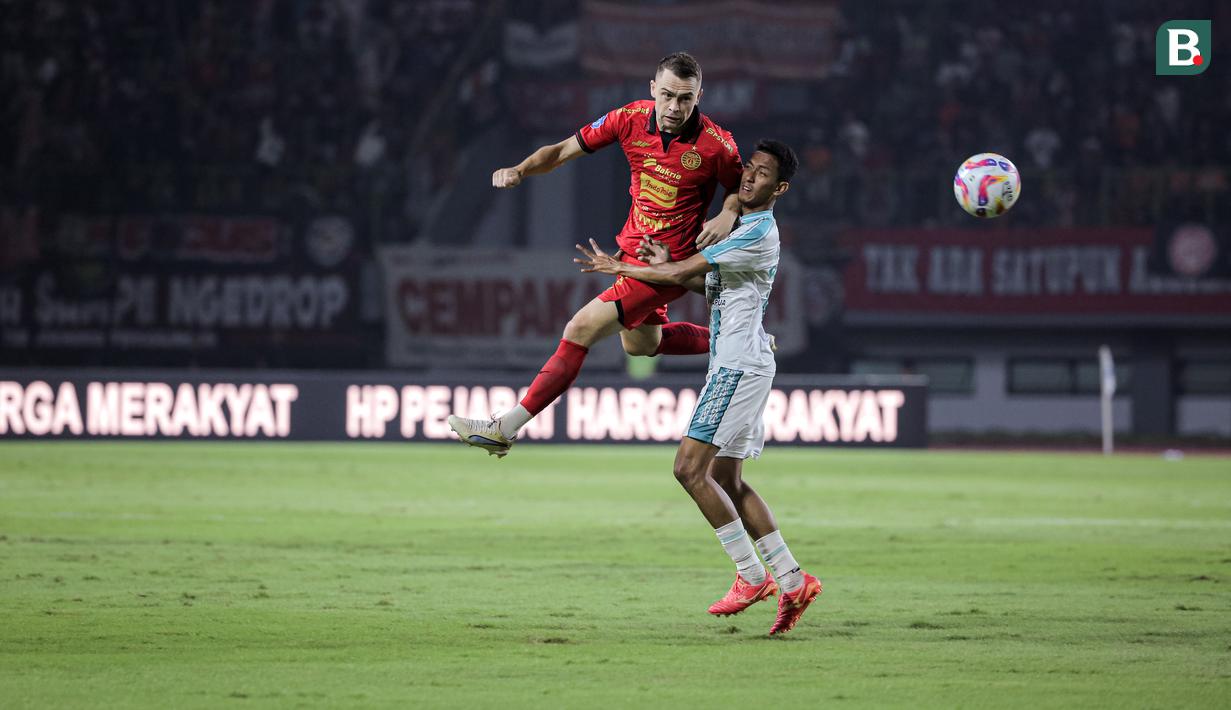 Pemain Persija Jakarta, Maciej Gajos berebut bola dengan pemain PSBS Biak, Arjuna Agung dalam laga lanjutan BRI Liga 1 2024/2025 di Stadion Patriot Candrabhaga, Bekasi, Minggu (02/02/2025). (Bola.com/Bagaskara Lazuardi)