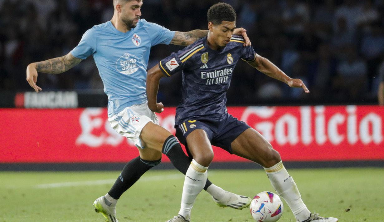 Pemain Real Madrid, Jude Bellingham, berebut bola dengan pemain Celta Vigo, Unai Nunez, pada laga Liga Spanyol di Stadion The Balaidos, Sabtu (26/8/2023). Madrid menang dengan skor tipis 1-0. (AP Photo/Lalo R. Villar)