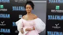Rihanna berpose untuk fotografer pada pemutaran perdana "Valerian and The City of a Thousand Planets" di Los Angeles, 17 Juli 2017. Penampilan Rihanna dengan gaun ekor yang menjuntai panjang menciptakan efek dramatis. (Neilson Barnard/GETTY IMAGES/AFP)