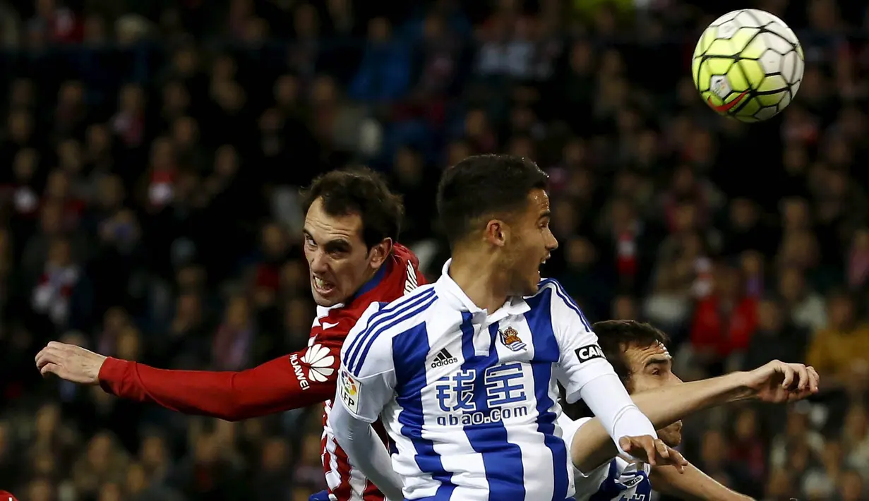 Pemain Atletico Madrid, Diego Godin (kiri) berebut bola dengan pemain Real Sociedad, Diego Reyes pada lanjutan La Liga di Vicente Calderon, Madrid, Rabu (2/3/2016) dini hari WIB. (REUTERS/Juan Medina)