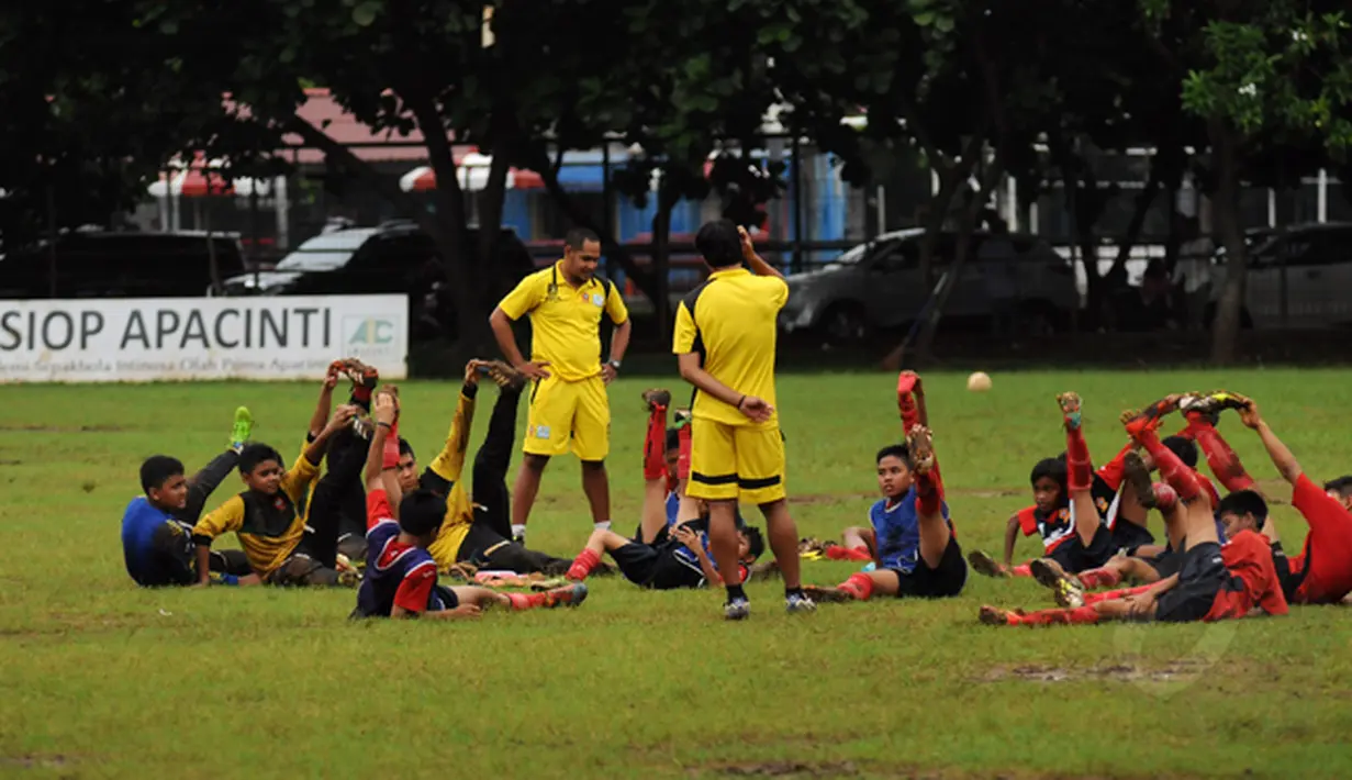Beberapa anak melakukan peregangan otot usai berlatih di Sekolah Sepak Bola ASIOP Apacinti di Lapangan A Senayan, Jakarta, Jumat (20/2/2015). (Liputan6.com/Helmi Fithriansyah)