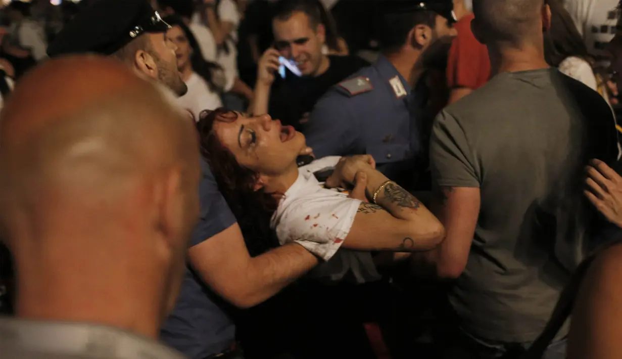 Seorang wanita dievakuasi karena mengalami luka-luka akibat ledakan saat nonton bareng final Liga Champions di Piazza San Carlo, Turin, Sabtu (3/6/2017). Acara nobar dipadati sekitar 20.000 supporter Juventus. (AFP/Marco Bertorello)
