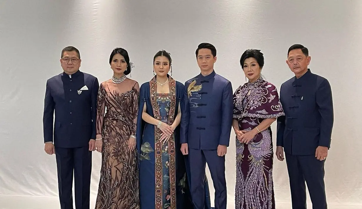 Sedangkan Liliana tampak menawan mengenakan cheongsam dress ungu dengan detail sheer off shoulder.