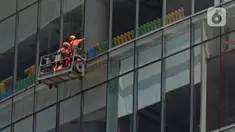 Pekerja membersihkan kaca gedung bertingkat di kawasan Jakarta, Kamis (2/4/2020). Dari 128 juta angkatan kerja di Indonesia, hanya 39% atau 50 jutaan pekerja yang terlindungi jaminan sosial ketenagakerjaan. (Liputan6.com/Herman Zakharia)