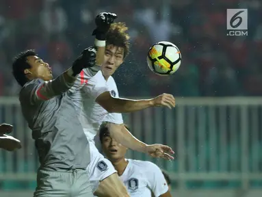 Penjaga gawang Timnas Indonesia U-23. M Ridho (tengah) berebut bola atas dengan pemain Korea Selatan U-23 pada laga persahabatan di Stadion Pakansari, Kab Bogor, Sabtu (23/6). Babak pertama Indonesia U-23 tertinggal 0-1. (Liputan6.com/Helmi Fithriansyah)